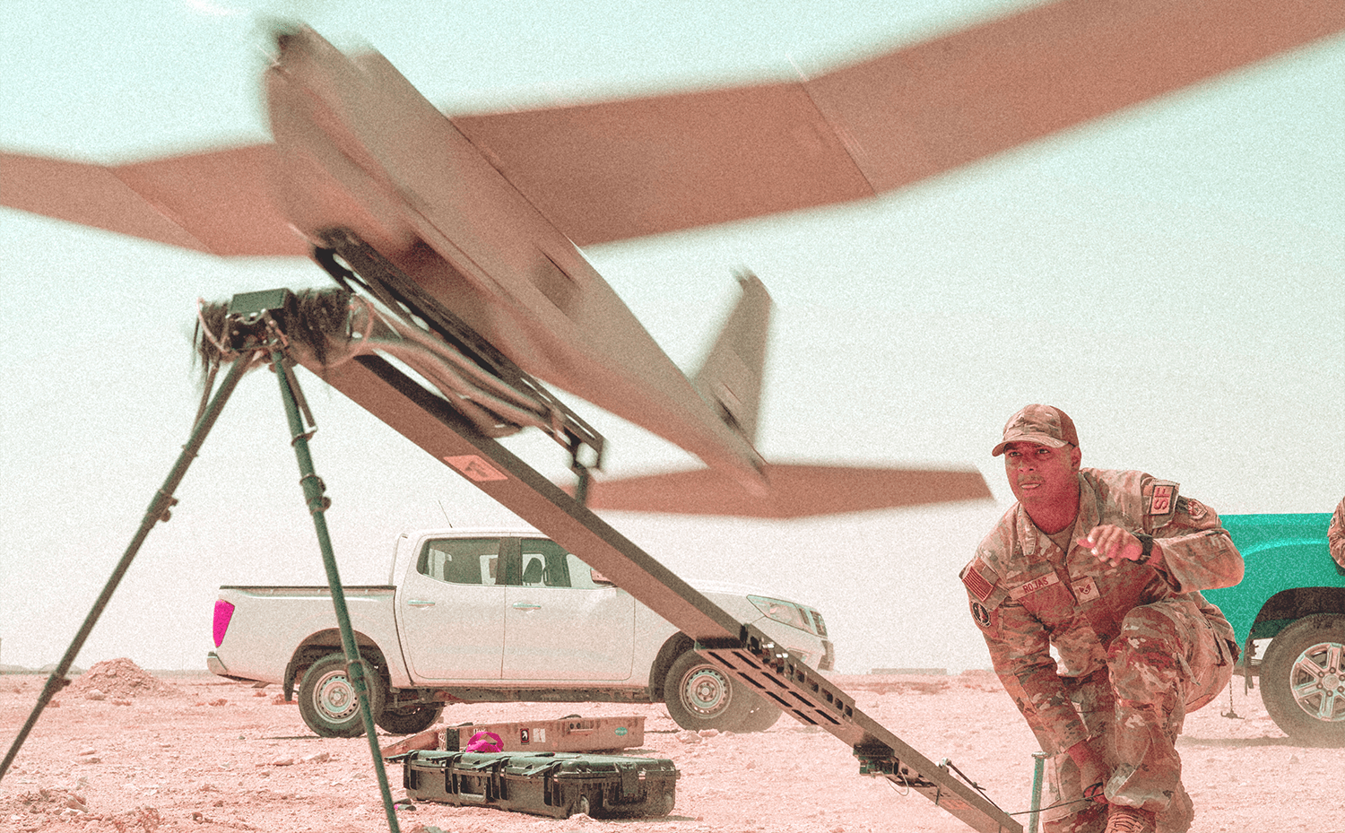 Soldier kneeling and launching a small unmanned craft